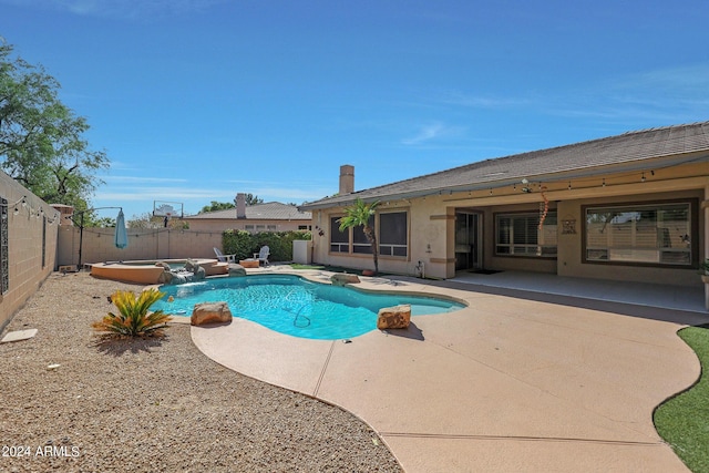 view of pool with a patio, pool water feature, and a jacuzzi