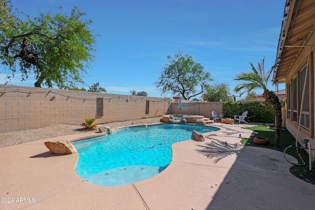 view of pool featuring an in ground hot tub, pool water feature, and a patio