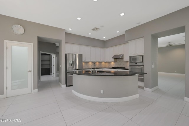 kitchen featuring sink, white cabinetry, a kitchen island with sink, stainless steel appliances, and decorative backsplash