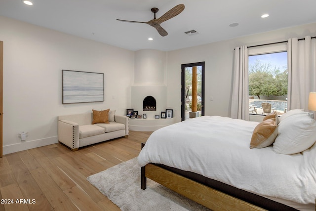 bedroom with ceiling fan, light hardwood / wood-style floors, and access to exterior