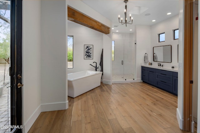 bathroom featuring hardwood / wood-style flooring, vanity, independent shower and bath, and an inviting chandelier