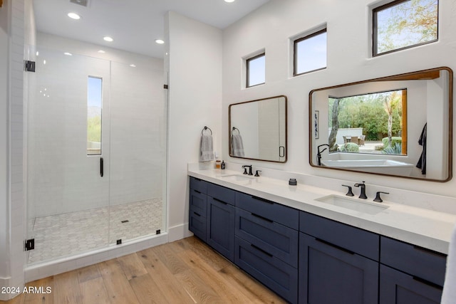 bathroom with hardwood / wood-style floors, vanity, and walk in shower