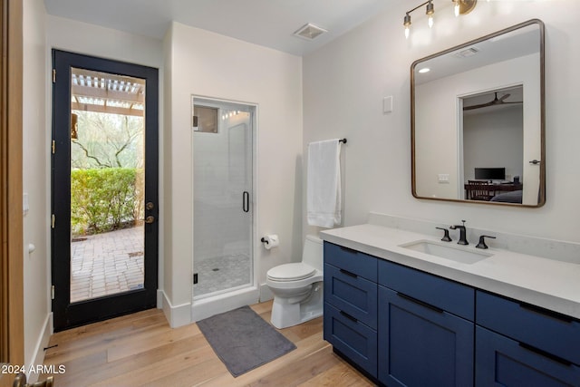 bathroom with vanity, wood-type flooring, an enclosed shower, and toilet