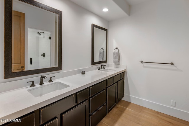 bathroom featuring hardwood / wood-style floors, vanity, and a shower with shower door