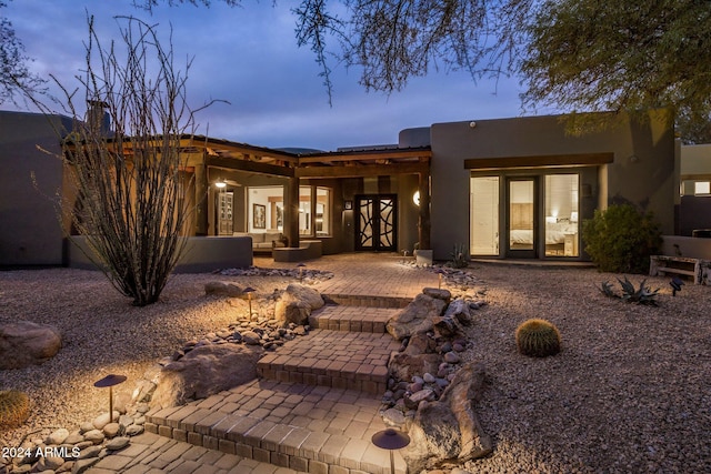 back house at dusk with a patio