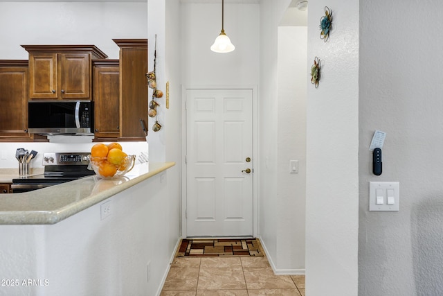 kitchen with stainless steel appliances, light tile patterned floors, and decorative light fixtures