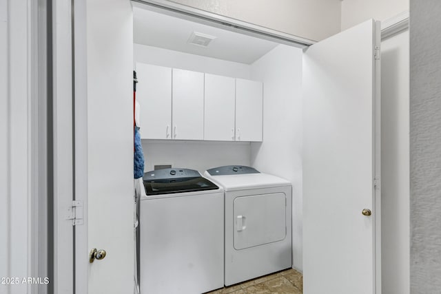 laundry room with washer and dryer and cabinets