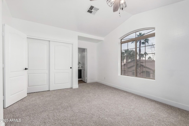 unfurnished bedroom with lofted ceiling, light colored carpet, ceiling fan, and a closet