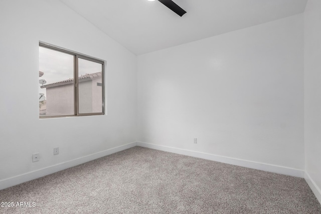 carpeted spare room featuring vaulted ceiling and ceiling fan