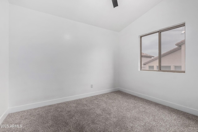 carpeted empty room featuring lofted ceiling