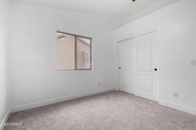 carpeted spare room featuring lofted ceiling