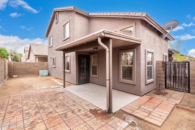 back of house with central AC unit and a patio