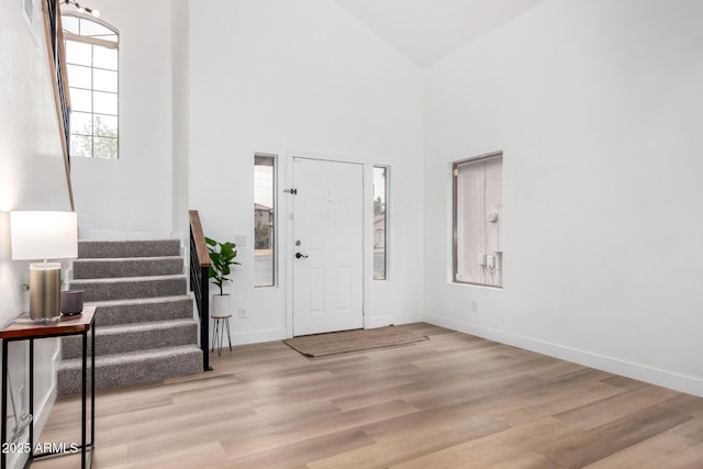 entrance foyer featuring a towering ceiling and light hardwood / wood-style floors