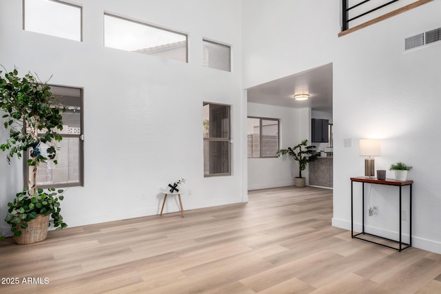 foyer featuring a towering ceiling and light hardwood / wood-style flooring