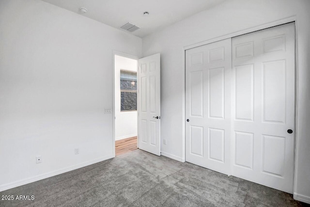 unfurnished bedroom featuring carpet and a closet