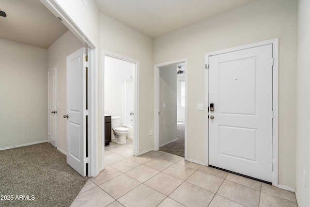 entryway featuring light tile patterned flooring, light carpet, and baseboards