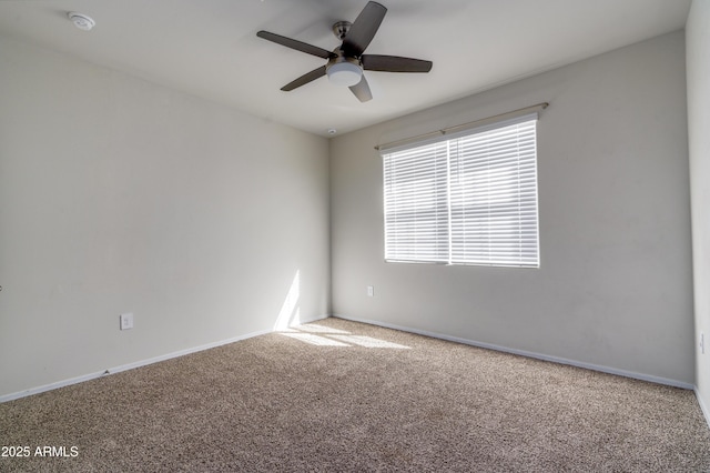 empty room featuring carpet floors, baseboards, and a ceiling fan