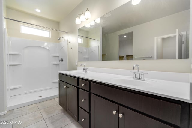 full bathroom with double vanity, a shower, a sink, and tile patterned floors