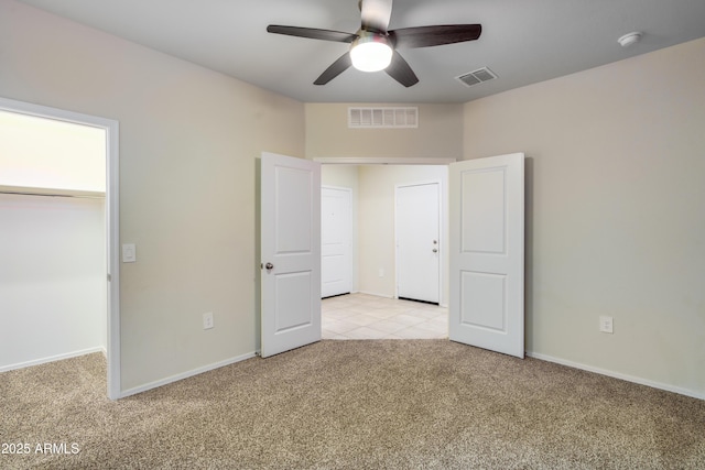 unfurnished bedroom with baseboards, ceiling fan, visible vents, and light colored carpet