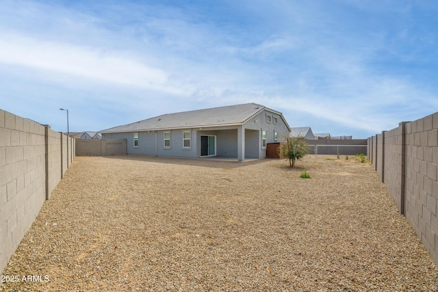 rear view of house with a fenced backyard