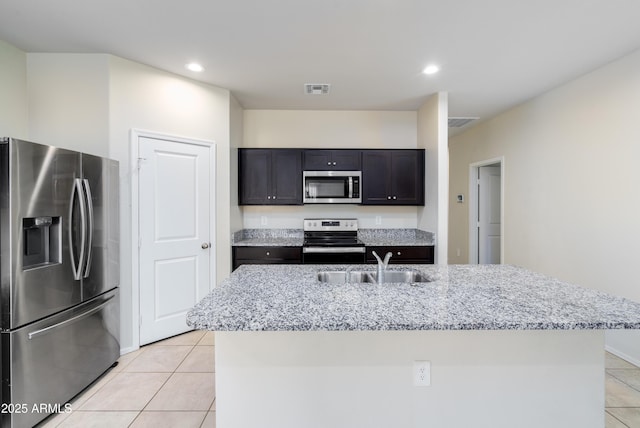 kitchen featuring light tile patterned floors, visible vents, appliances with stainless steel finishes, light stone countertops, and a sink