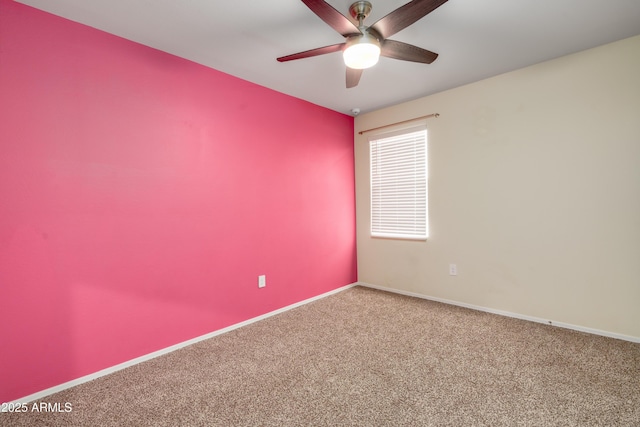 carpeted spare room with ceiling fan and baseboards