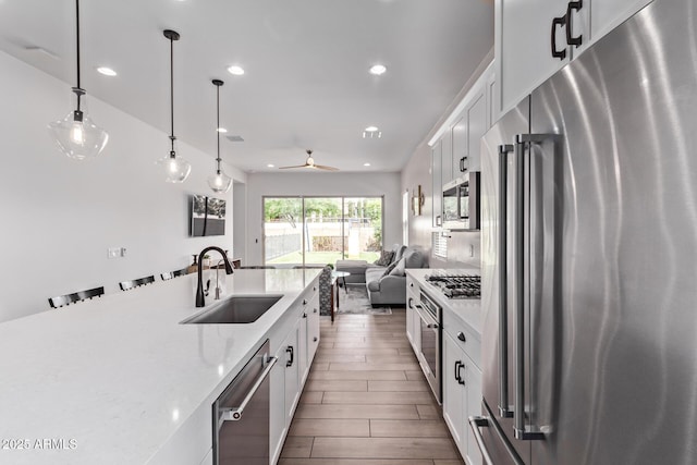 3031 S Valerie Dr, Chandler, AZ 85286 - kitchen featuring white cabinets, stainless steel appliances, open floor plan, and a sink