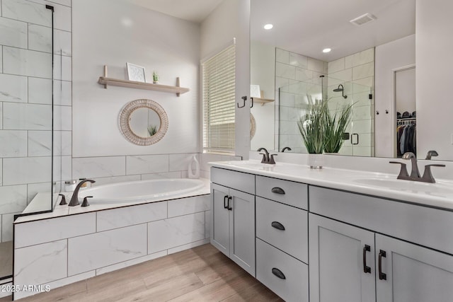 3031 S Valerie Dr, Chandler, AZ 85286 - full bathroom featuring visible vents, wood finished floors, a bath, a sink, and a stall shower