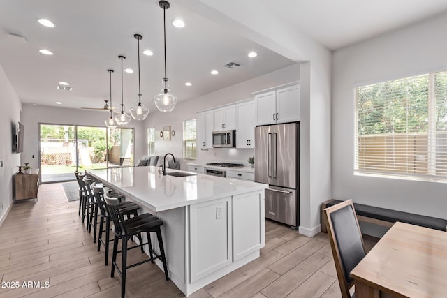 3031 S Valerie Dr, Chandler, AZ 85286 - kitchen featuring visible vents, light wood-style floors, white cabinetry, a sink, and appliances with stainless steel finishes
