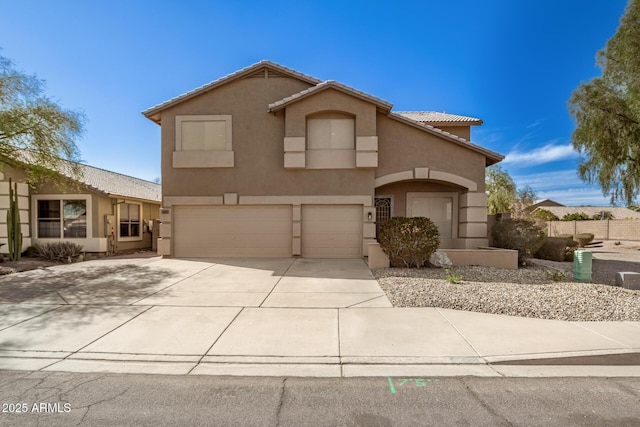 view of front facade featuring a garage, driveway, a tiled roof, and stucco siding