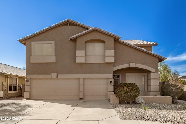 view of front of home featuring driveway, a tiled roof, an attached garage, and stucco siding