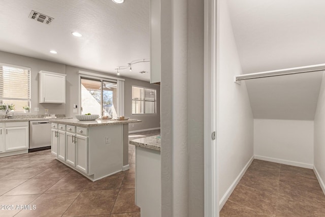 kitchen with light stone counters, a center island, visible vents, stainless steel dishwasher, and white cabinets