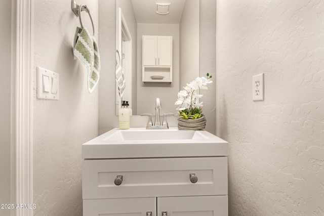 bathroom featuring vanity and a textured wall