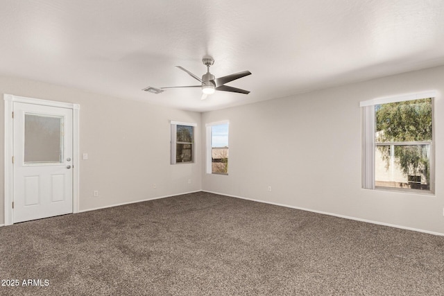 carpeted empty room featuring ceiling fan and visible vents