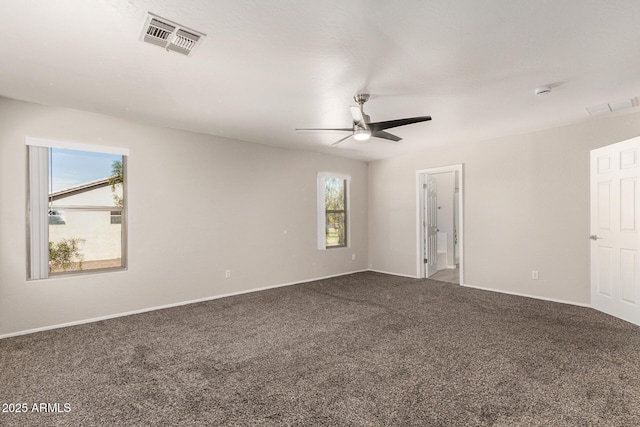 unfurnished room featuring baseboards, dark colored carpet, visible vents, and a ceiling fan