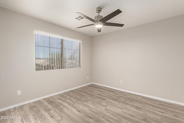 empty room with visible vents, light wood-style flooring, and baseboards