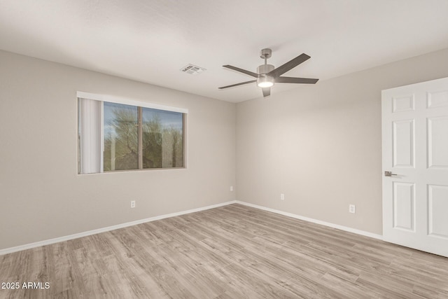 empty room featuring light wood-type flooring, baseboards, visible vents, and a ceiling fan