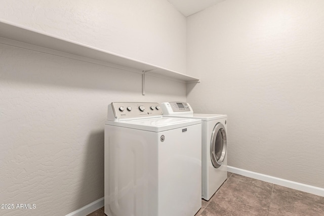 laundry room featuring washer and dryer, laundry area, a textured wall, and baseboards