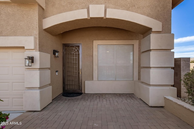 entrance to property featuring stucco siding