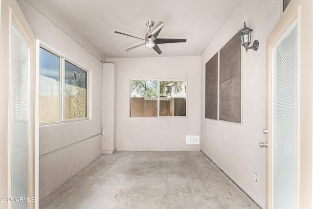 empty room with a ceiling fan, visible vents, and concrete floors