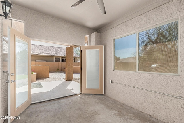 interior space featuring concrete flooring, a healthy amount of sunlight, and ceiling fan