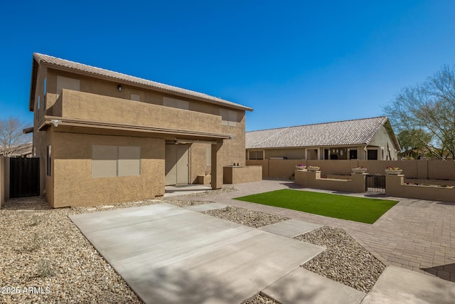 back of house with a patio area, a fenced backyard, and stucco siding