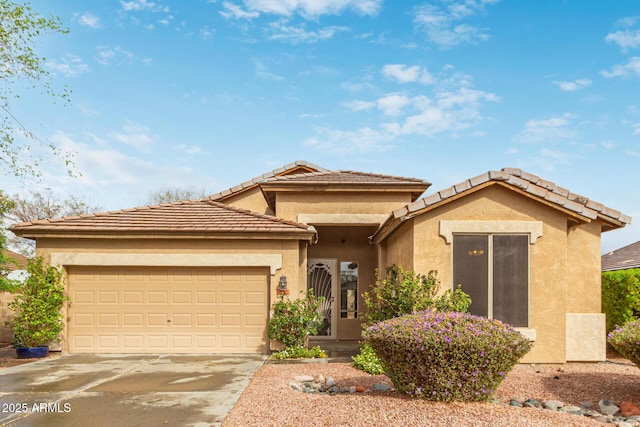 view of front of home featuring driveway, an attached garage, and stucco siding