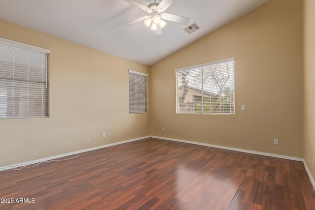 spare room featuring wood finished floors, visible vents, baseboards, vaulted ceiling, and a ceiling fan