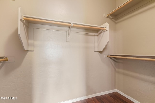 spacious closet with dark wood-style floors