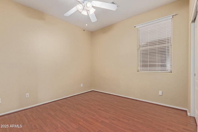 unfurnished room with ceiling fan, wood finished floors, visible vents, and baseboards