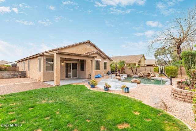 back of house with a fenced in pool, a yard, stucco siding, a patio area, and a fenced backyard