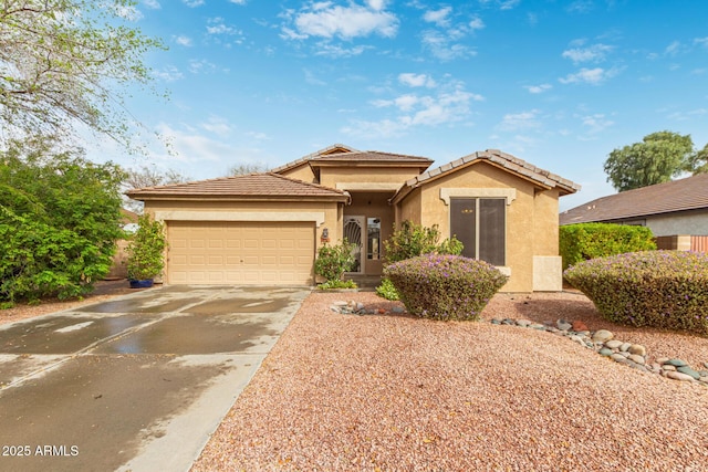 view of front of home featuring a garage, concrete driveway, and stucco siding