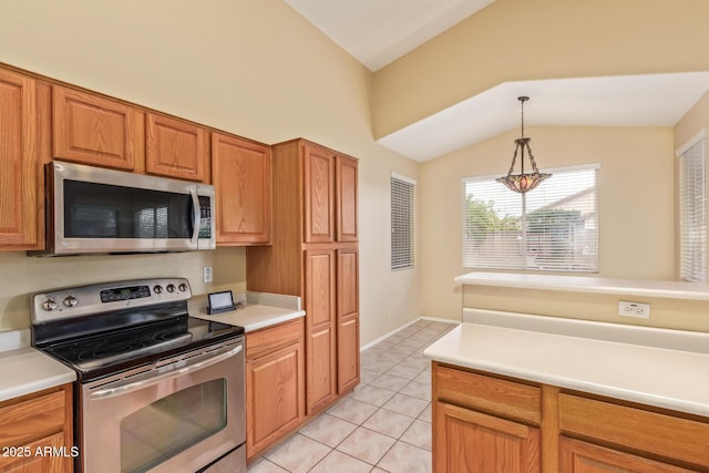 kitchen featuring light tile patterned floors, hanging light fixtures, vaulted ceiling, stainless steel appliances, and light countertops