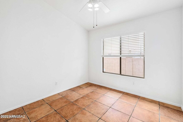 spare room featuring light tile patterned floors, ceiling fan, and baseboards